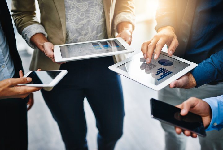 tres mujeres en ropa formal usando tabletas en un evento