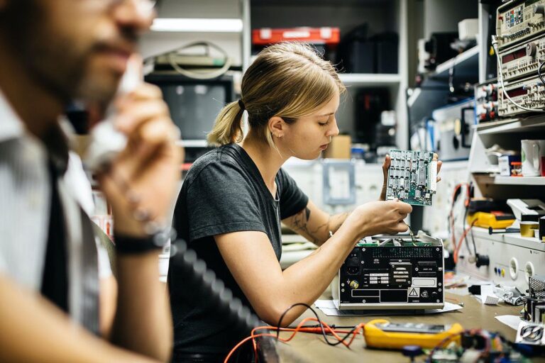 Equipe consertando equipamentos de TI em laboratório